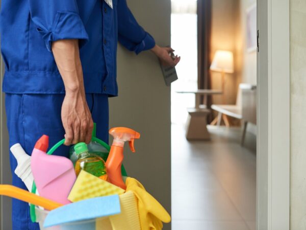 unrecognizable-cleaner-walking-into-hotel-room-with-tools-detergents_1098-17830